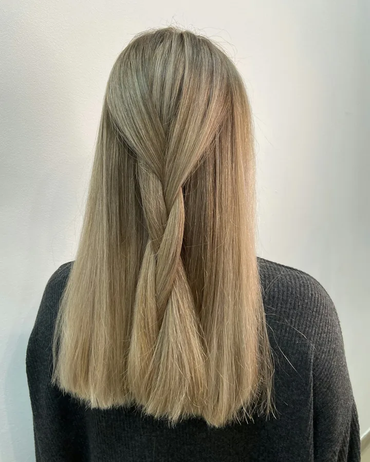Cheveux blonds lisses avec une demi-tresse, vus de dos