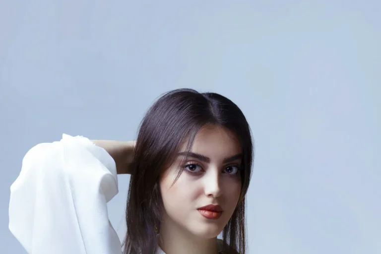 Jeune femme posant en chemise blanche lors d’une séance photo en studio